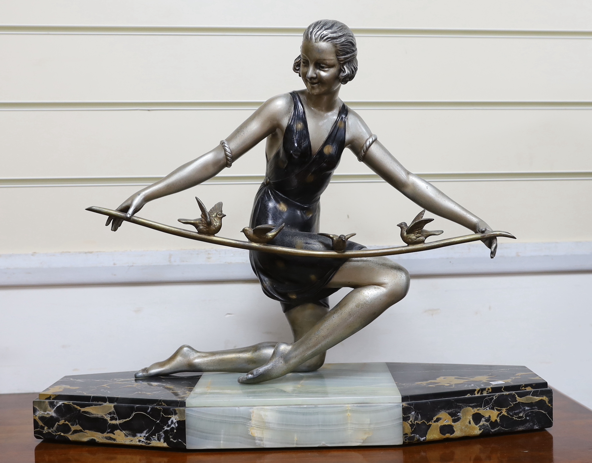 An Art Deco spelter figure of a lady on marble base, signed Arris?, 56cm wide